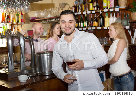 Bartender entertaining guests Bartender entertaining guests 19019916