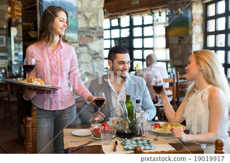 Waitress serving couple in a restaurant Waitress serving couple in a restaurant 19019917
