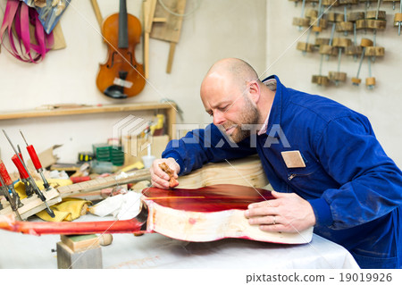 Man varnishing a guitar 19019926