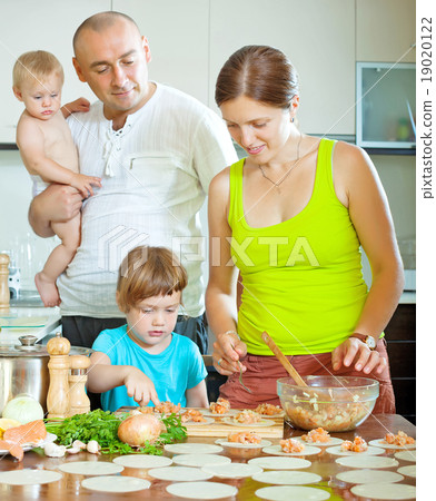 family of four making delicious dumplings stuffed with fish 19020122
