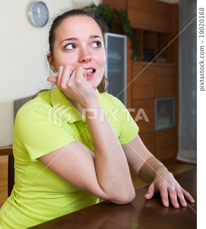 Woman sitting and biting nails 19020168