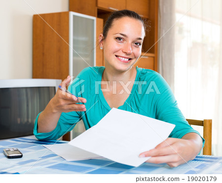 Girl with papers at the table at home 19020179