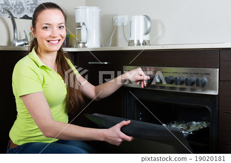 Woman cooking meal in the oven 19020181