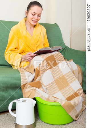 Woman in bathrobe with feet in basin 19020207