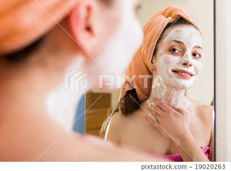 Girl applying cream on skin 19020263