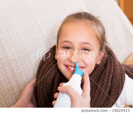 Woman treating daughter for rhinitis 19020425