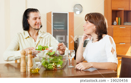 beautiful woman with man eating veggie salad at home 19020456