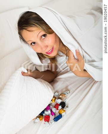 Female eating sweets in bed 19020457