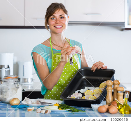 housewife putting pieces of white fish in tray housewife putting pieces of white fish in tray 19020656