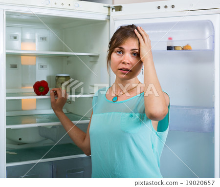 hungry girl near empty fridge 19020657