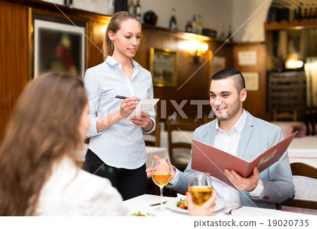 Cheerful waitress taking a table order 19020735