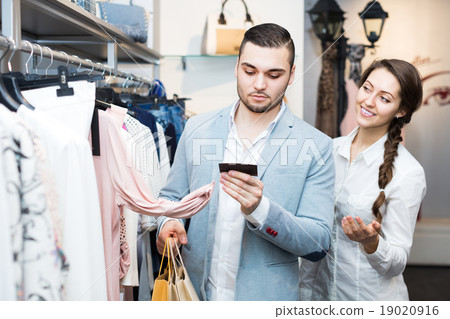 Customer consulting with shop assistant 19020916