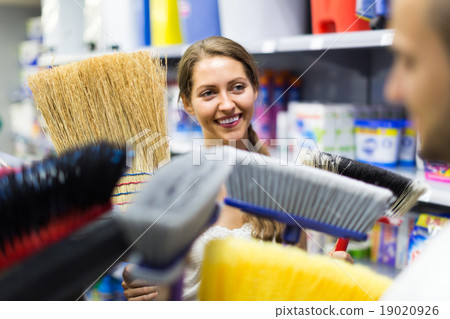 Customers selecting broom at store. 19020926
