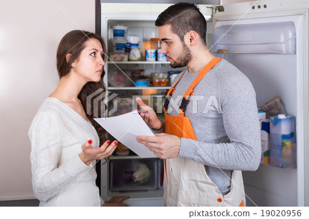 Repairman and housewife at kitchen 19020956