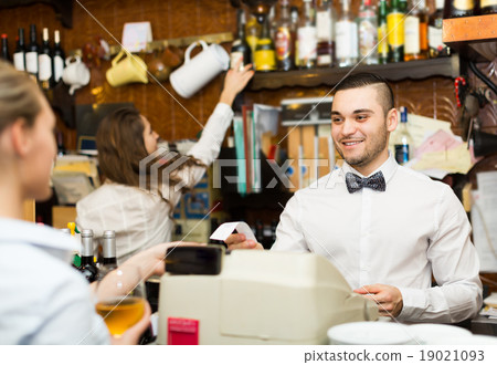 Girl flirting with barman at counter 19021093
