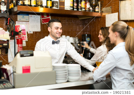 Bar staff working at a bar 19021381