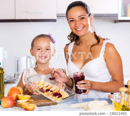 Mother and daughter preparing pie 19021491