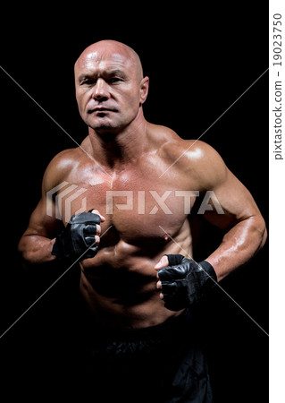 Portrait of confident man with fighter stance 19023750