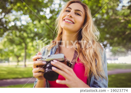 Portrait of happy woman holding camera Portrait of happy woman holding camera 19023774