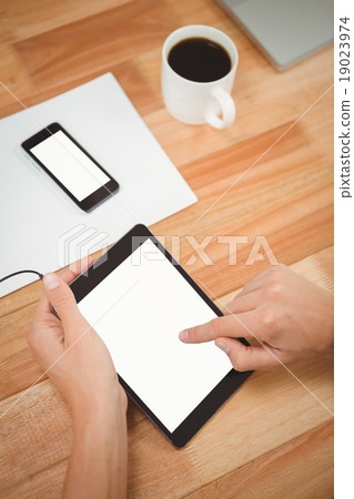 Man using digital tablet with smartphone and coffee on table Man using digital tablet with smartphone and coffee on table 19023974