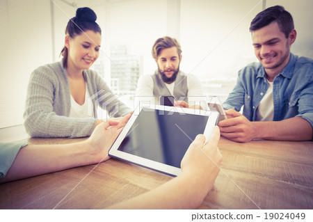 Cropped hand holding digital tablet with people using smartphone 19024049