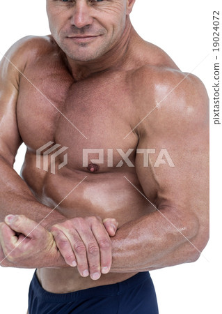 Midsection of smiling bodybuilder flexing muscles 19024072
