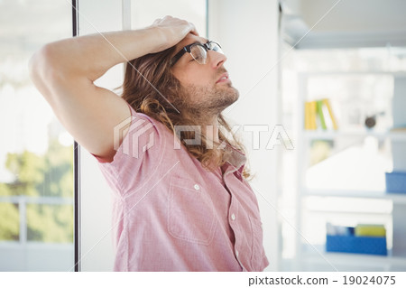 Side view of tired hipster with hand on head 19024075