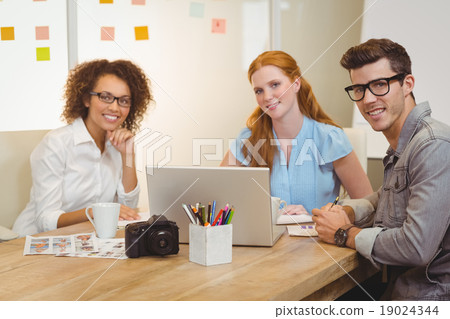 Colleagues using laptop during meeting with businesswoman Colleagues using laptop during meeting with businesswoman 19024344