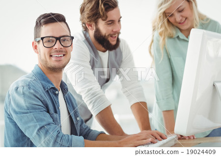 Portrait of smiling man at computer desk Portrait of smiling man at computer desk 19024409