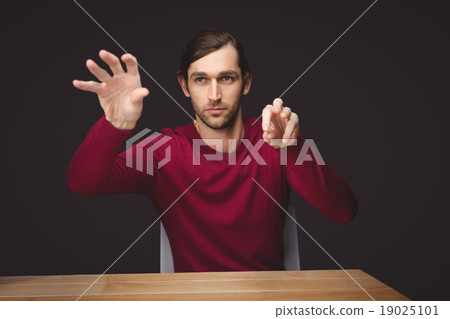 Man gesturing while sitting at desk Man gesturing while sitting at desk 19025101