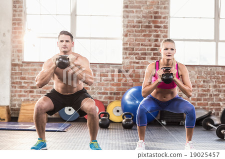 muscular serious couple with kettlebells muscular serious couple with kettlebells 19025457