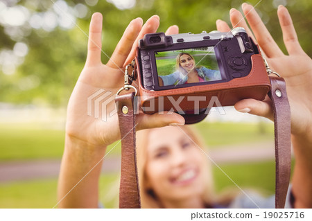 Smiling woman taking self portrait Smiling woman taking self portrait 19025716