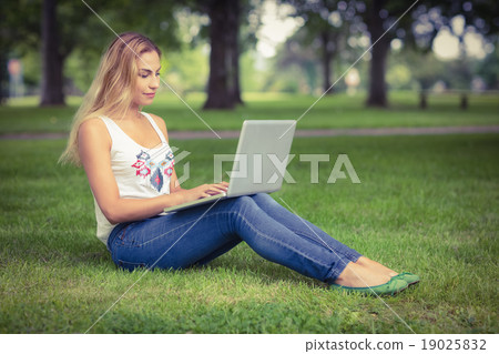 Full length of woman using laptop at park Full length of woman using laptop at park 19025832