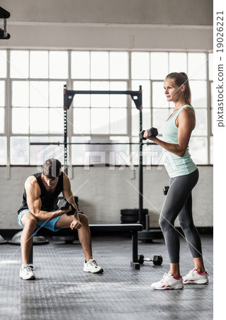 Sporty couple exercising with dumbbells 19026221