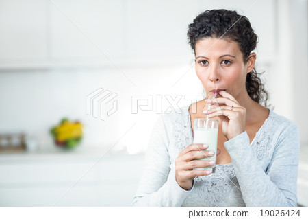Pregnant woman drinking a glass of milk Pregnant woman drinking a glass of milk 19026424