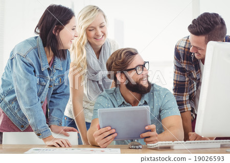 Happy business people using digital tablet at computer desk Happy business people using digital tablet at computer desk 19026593