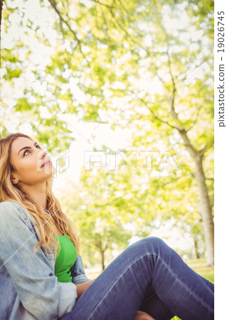 Smiling woman looking up at park Smiling woman looking up at park 19026745