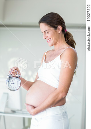 Happy woman with alarm clock 19027202