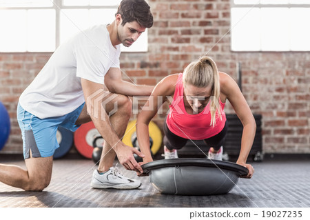 Trainer motivating client doing push ups 19027235
