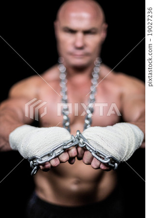 Portrait of confident man with bandage and chain Portrait of confident man with bandage and chain 19027236