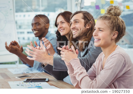 Happy business people clapping at desk Happy business people clapping at desk 19027350