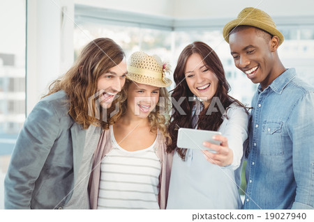 Smiling business team taking selfie at office Smiling business team taking selfie at office 19027940