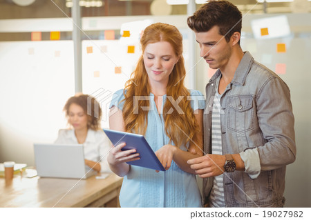 Businesswoman showing digital PC to businessman Businesswoman showing digital PC to businessman 19027982