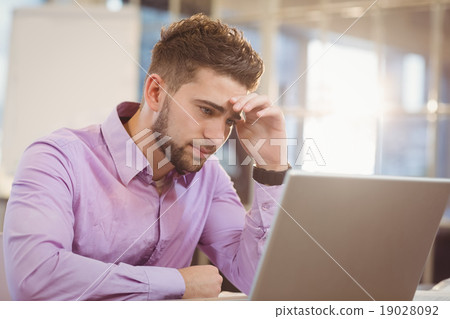 Worried businessman looking at laptop 19028092