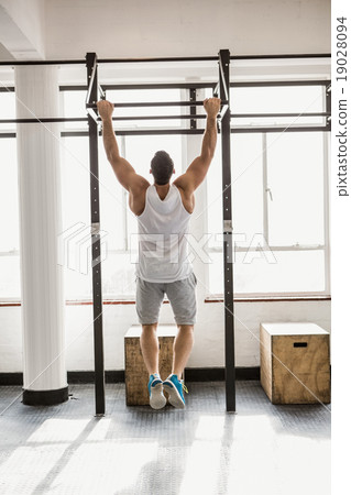 Rear view of man doing pull ups 19028094