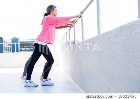 Women leaning on railing while exercising 19028453