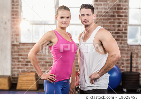 Standing muscular unsmilling couple facing the camera 19028455