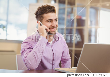 Businessman calling on phone in office Businessman calling on phone in office 19029073