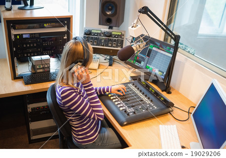 Female radio host operating sound mixer 19029206