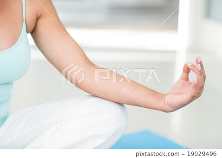 Pregnant woman doing yoga on exercise mat 19029496